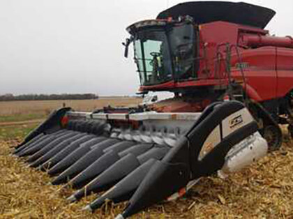 G T S corn head attached to a combine in a corn field