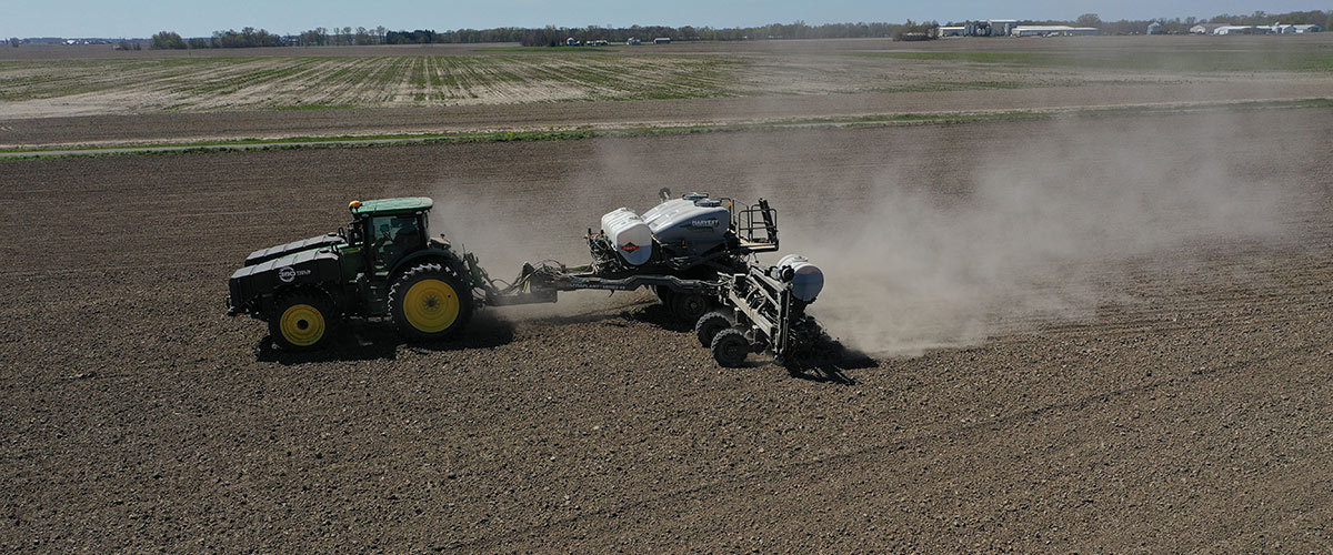 tractor pulling a Harvest International planter in a field